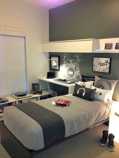 a bedroom with a bed, desk and computer on the wall in front of it