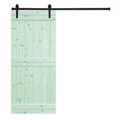 an open sliding door with green paint and black metal bars on the bottom, in front of a white background