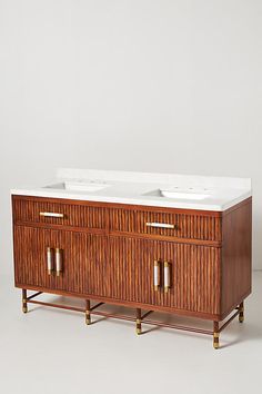 two white sinks sitting on top of a wooden cabinet