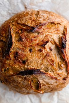 a loaf of bread sitting on top of a piece of wax paper covered in brown stuff