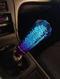 a blue and purple vase sitting on the dashboard of a car