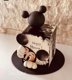 a mickey mouse birthday cake on a black plate