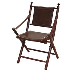 a brown leather folding chair with wooden arms and back rests on a white background,