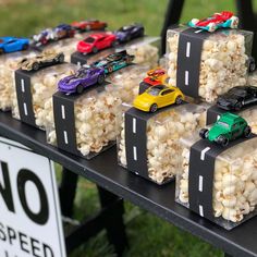 there are many cars on the table with popcorn in front of them and a sign that says no speed limit