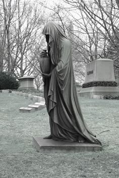 black and white photograph of a statue in the middle of a cemetery with headscarves