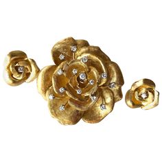 An 18 karat gold and diamond rose flowering brooch and matching earrings created by Cartier of France. The set has a Florentine finish to the petals with 15 full cut diamonds in the brooch, some of them en tremblant. The earrings have one single diamond each. Brooch measures 2" by 2" and is signed Cartier, 18K. The earrings are of pierced variety, measure .75" in diameter and are unsigned, testing positive for 18K. Earrings can be worn as scatter pins as seen in my last picture. In very good vin Cartier Gold, Jewelry Design Studio, Mid Century Jewelry, Gold Bangles Design, Rose Earrings, Small Jewelry, Flower Brooch, Vintage Brooches, Earrings Set