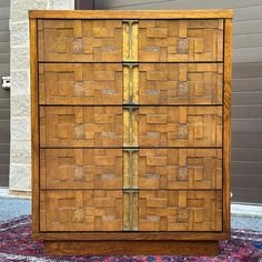 a wooden dresser with several drawers on top of it and a rug in front of the door