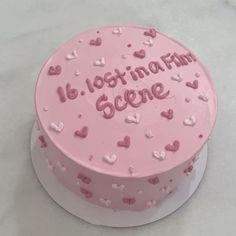 a pink frosted cake with hearts and the words it's lost in a film