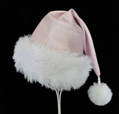 "Pastel pink polyester fabric with metallic silver glittered sparkle accents makes up this novelty Santa hat in classic Santa hat styling. Hat is fully lined with a white cotton fabric and there is a soft and fluffy white faux fur fabric turn up brim for the trim and a white faux fur pompom dangle.  Proportions of the hat are generous and will fit most head sizes, ladies or gents.  Measurement for opening for your head is 24-25\" circumference and the length is 20\". Check measurements to make s White Mini Hats For Winter Party, Pink Winter Party Hats, Hat Styling, Pink Santa Hat, 2000s Pink, Santa Claus Costume, White Cotton Fabric, Fur Fabric, Christmas Celebration