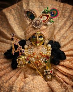 a close up of a person wearing a costume and headdress with pearls on it