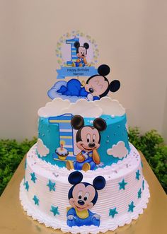 a three tiered cake with mickey and minnie mouse decorations