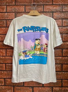 "Vintage 90s The Flintstones American Animated Cartoon Pop Art Graphic T Shirt / 90s Streetwear T Shirt Size L Condition : Good Used Size on tag : L Colour : white Brand : Xox Measurement : Armpit to armpit - 20.5\" Length - 25\" Material : Cotton Made In: Thailand THE SHIPPING (Your Choice Please read) 1. The shipping cost is USD 20 via Malaysian Registered Postage With Tracking Number. It will take 2-4 weeks or more for delivery, depends on your custom checking. 2. Add USD 10 for speedy delive Cheap Pop Culture T-shirt With Character Print, Vintage Cartoon Shirt, Cartoon Pop Art, Cartoon Pop, Teen Swag, Teen Swag Outfits, The Flintstones, Streetwear T Shirt, 90s Streetwear