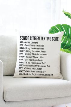 a white couch sitting next to a window with a pillow on top of it that says senior citizen texting code