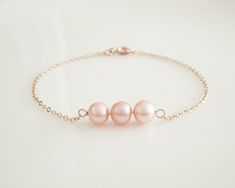 This  beautiful pearl bracelet is hand-crafted using AAA  freshwater pearls and gold-filled chain . The Pearl Bracelet features 3 Peach freshwater pearls, hand picked for their radiant luster. It is also available in several different size. The bracelet is finished with an easy to use a gold filled clasp. This elegant bracelet would make a great gift for bridesmaids, friends, mother and daughter.  Pearl Type:     Freshwater Pearl Grade:            AAA,  Pearl Color:    Peach Pearl Size:      5-6 Pink Pearl Drop Bracelet As Gift, Delicate Rose Gold Pearl Bracelet, Pink Pearl Chain Bracelet As Gift, Rose Gold Pearl Bracelet As Gift, Pink Pearl Bracelet, Pearl Bracelet Wedding, Flower Girl Wedding, Creative Jewelry Photography, Flower Girl Jewelry