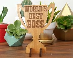 a wooden trophy with the words world's best boss on it