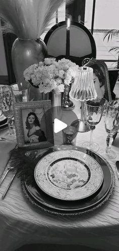 black and white photograph of table setting with flowers, wineglasses, candles and pictures