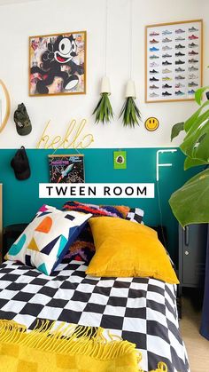 there is a bed with yellow and black sheets in the room that has pictures on the wall