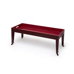 a long red tray with wheels on the bottom is sitting in front of a white background