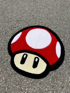 a close up of a mushroom rug on the ground with a person's face painted on it