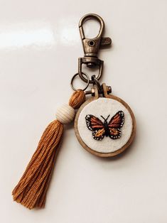 a keychain with a butterfly on it and a tassel hanging from the front