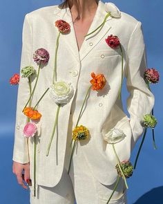 a woman wearing a white suit with flowers on it