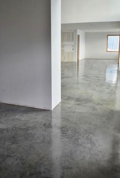 an empty room with concrete floors and white walls