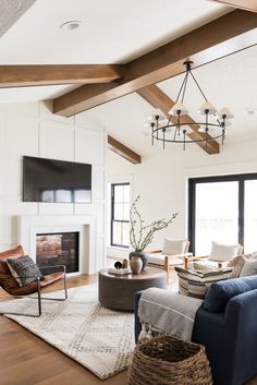 a living room filled with furniture and a flat screen tv mounted on the wall above a fireplace