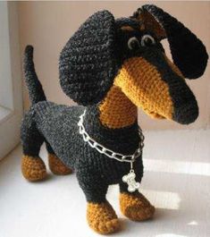 a crocheted dachshund dog with chains on it's neck