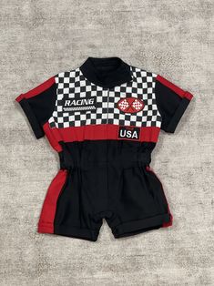 a black and red racing uniform with the usa on it's chest, sitting on a gray surface