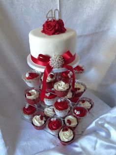 a wedding cake and cupcakes on a table