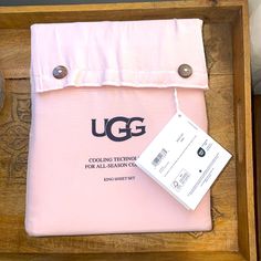 the ugg bag is pink and has a tag on it