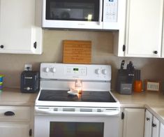 a white stove top oven sitting inside of a kitchen next to a microwave above it