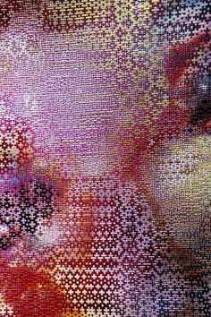 an abstract painting made up of many different colored squares and dots, with one eye looking at the camera