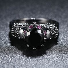 a black diamond ring sitting on top of a table