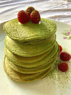 a stack of green pancakes with strawberries on top