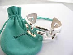 Overview:Offered for sale is a wonderful, super cool, and gorgeous Tiffany & Co Sterling Silver Puzzle Wide Cuff / Bracelet. Definitely a Tiffany piece that you will get your money's value for. It works perfectly with pretty much any attire your put on, AND is the perfect Tiffany statement piece. It is the perfect piece that fits a lifestyle on the go -- the cuff can be worn to pretty much any occasion! It is simple, elegant, and classic all rolled into one bracelet - it looks awesome worn alone Pearl Bracelets Tiffany & Co., Tiffany And Co Bracelet, Wide Cuff Bracelets, Cuff Bangle Bracelet, Wide Cuff, Gift Pouch, Weekend Outfit, Weekend Wear, Cuff Bangles