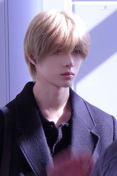 a male model with blonde hair wearing a black jacket