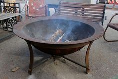 a fire pit sitting on top of a cement ground