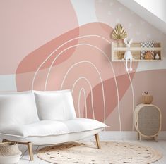 a white couch sitting on top of a rug in front of a wall painted pink