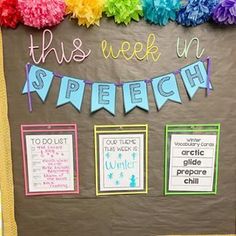 this week in speech bulletin board is decorated with colorful paper pom - poms