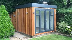 a small wooden shed sitting in the middle of a garden