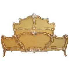 a gold colored bed with ornate headboard and foot board