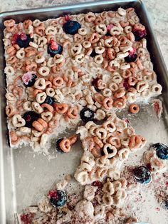 an uncooked pizza with cereal and berries on it