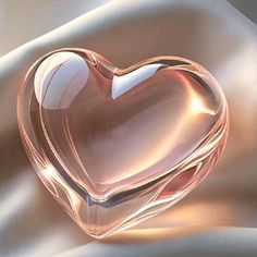 a glass heart sitting on top of a white cloth