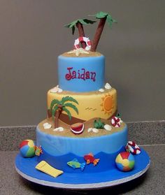 a three tiered cake decorated with beach scenes and palm trees