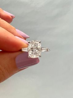 a woman's hand holding an engagement ring