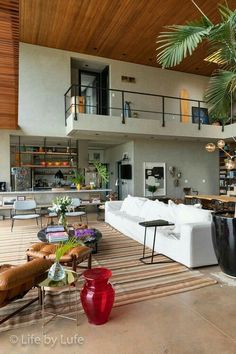 a living room filled with furniture next to a tall wooden ceiling covered in bookshelves