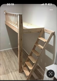 there is a wooden staircase next to the bed