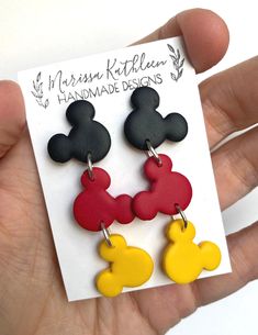 the mickey mouse earrings are red, yellow and black with two ears on each ear