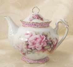 a white tea pot with pink flowers on it